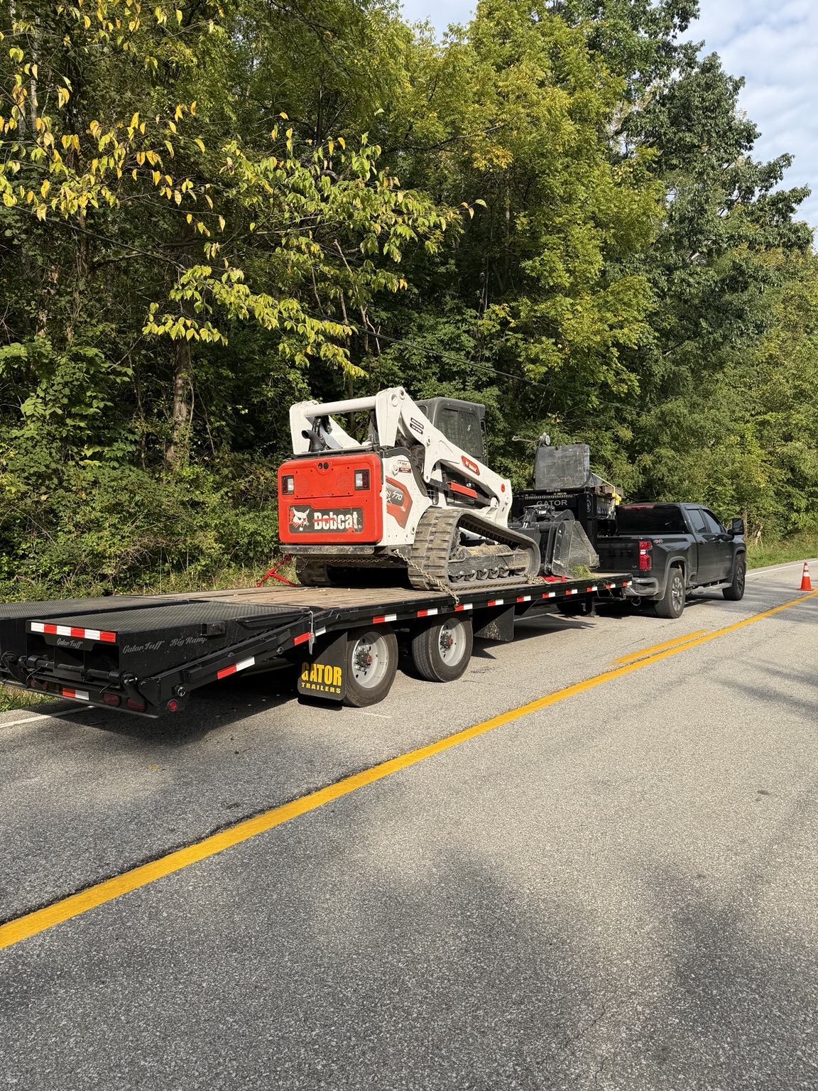 Starrett Junk Removal Bobcat T770 skid steer secured on a heavy equipment trailer